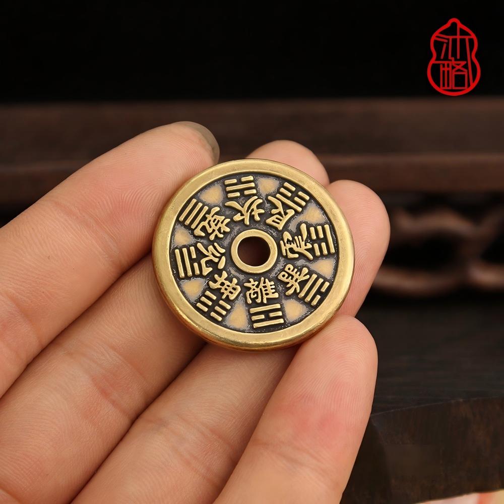 Vajra Knot Shan Gui Keychain – hand holding reverse side showing Bagua trigrams, round hole, dark wood background, spiritual keychain