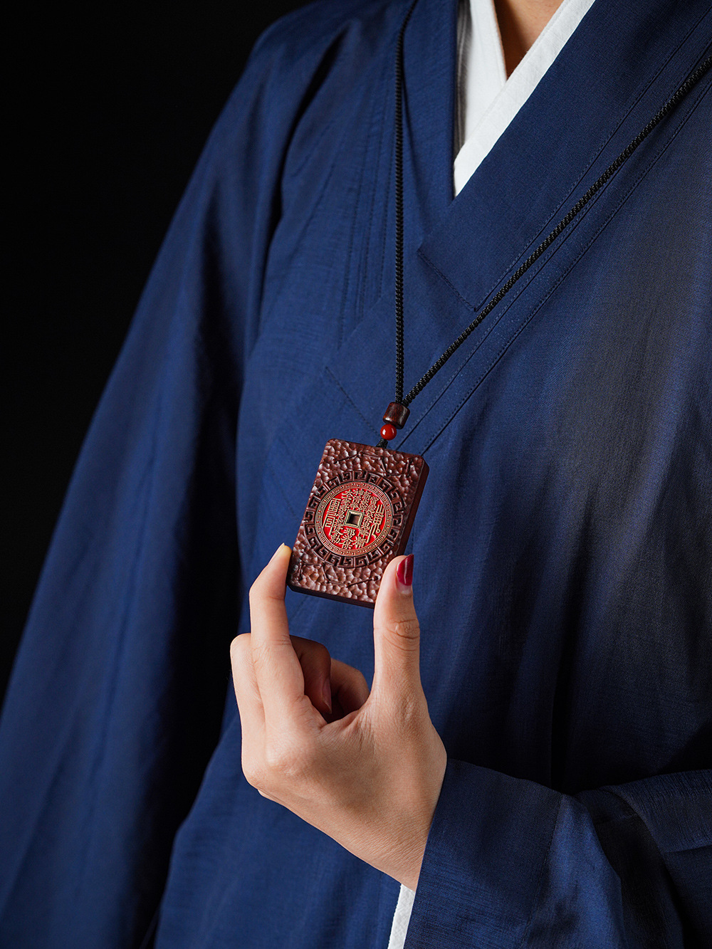 Shan Gui Wood Pendant – blue traditional dress model wearing, black cord protection charm