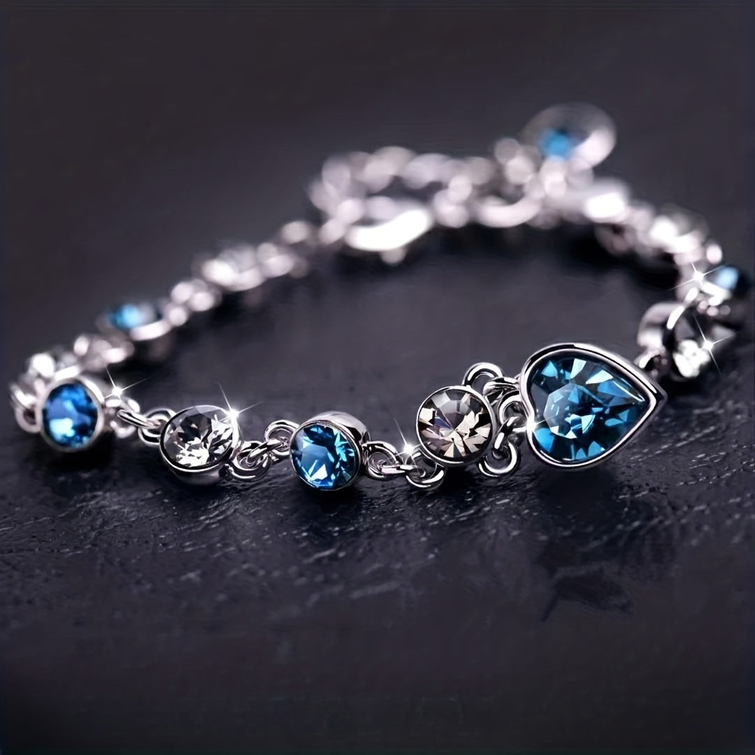 Heart of Ocean Bracelet – teardrop sapphire crystal with alternating round gems on dark background, luxury