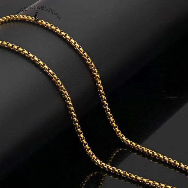 Zodiac Spin Necklace – gold box chain close up, black reflective background showing metal link detail, Buddhist necklace chain