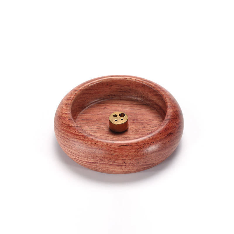 Three-hole brass insert on reddish wood incense bowl white background, healing