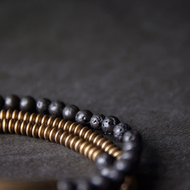Lava Rock Copper Healing Bracelet – Black volcanic bead bracelet with copper center and silver metal accents, white background e-commerce product photo front view
