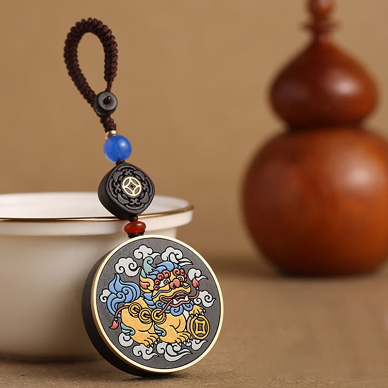 PiXiu Coin Keychain – Beside white teacup with wooden gourd in warm tan background