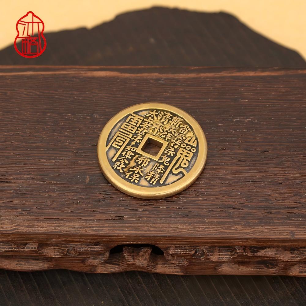 Vajra Knot Shan Gui Keychain – brass coin on wood surface with mountain silhouette, warm tones, red seal logo, protection charm keychain