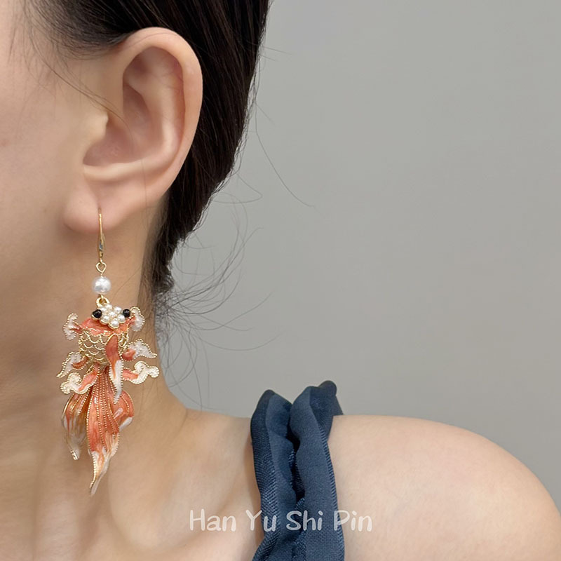 Koi Earrings – Model wearing orange enamel koi fish dangle earring with pearl, gray background Chinese style luck grace