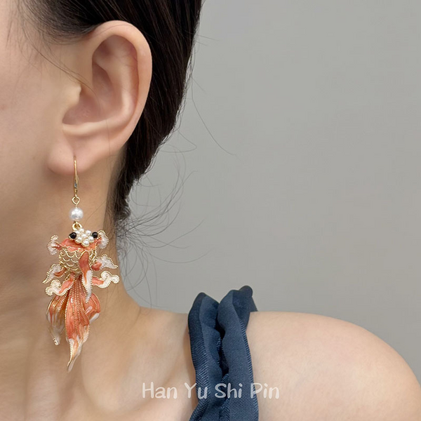 Koi Earrings – Model wearing orange enamel koi fish dangle earring with pearl, gray background Chinese style luck grace