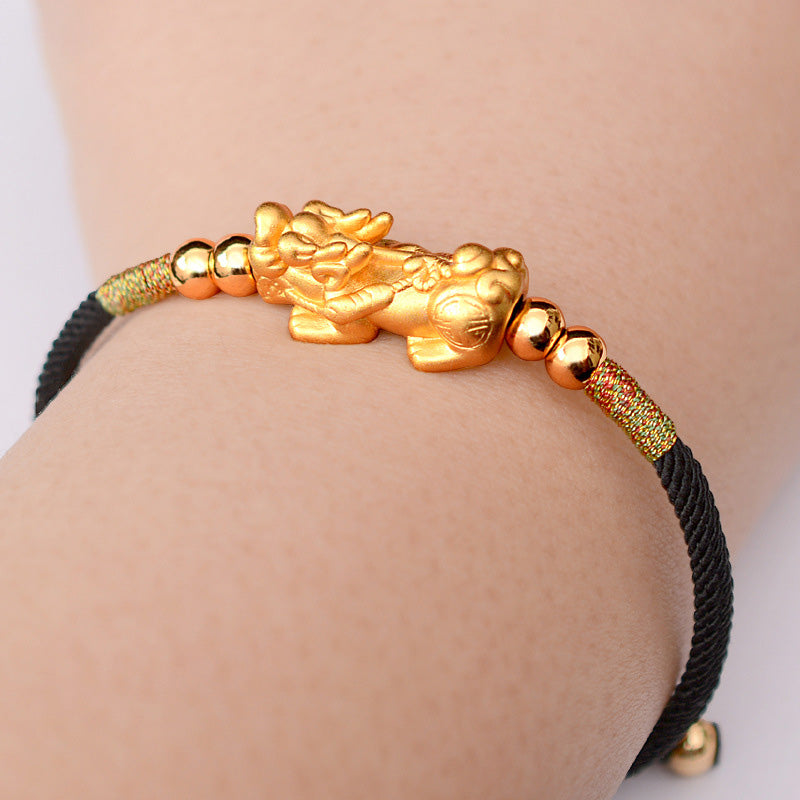 Gold-Plated PiXiu Red String Bracelet – gold PiXiu on black cord bracelet worn on wrist, unisex wealth accessory