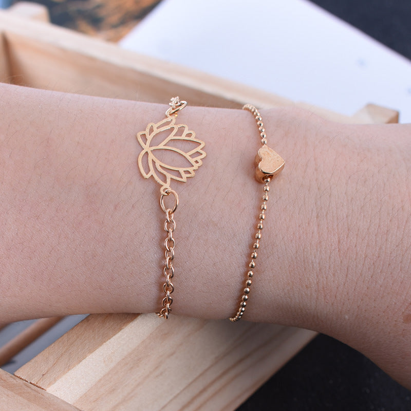 Lotus Heart Enlightenment Bracelet - Rose gold lotus heart bracelet worn on wrist near wood, love purity