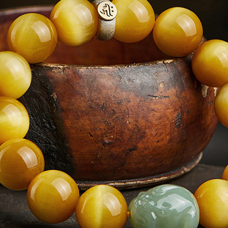 Zodiac Tiger Eye Jade Bracelet – Close-up tiger eye beads jade PiXiu on rustic pottery