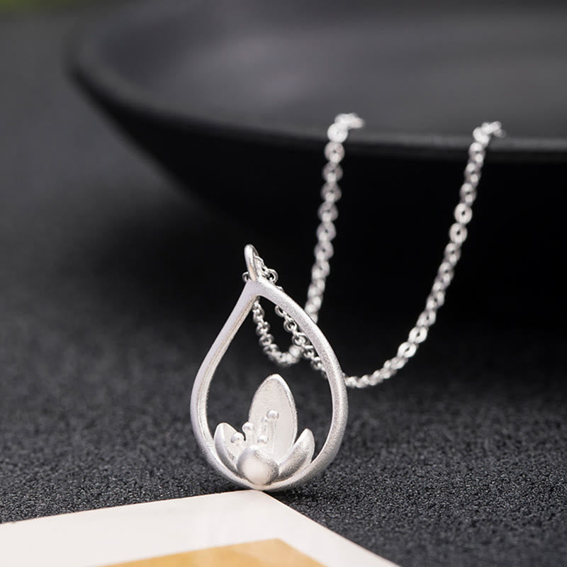 Sterling Silver Lotus Pendant – Low angle on dark fabric, matte finish, Mindful
