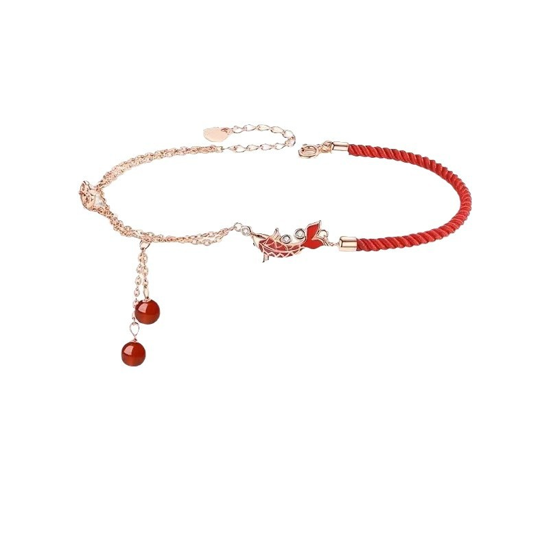 Shang An Koi Anklet – flat lay of red cord anklet with rose gold chain, koi charm and red agate drops on white background