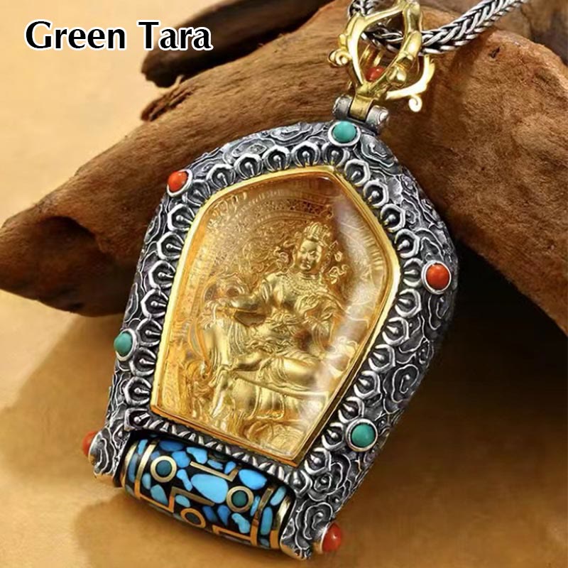 Tibetan Zodiac Buddha Dzi Bead Necklace – Gold Tara deity pendant in ornate silver frame with turquoise coral and prayer wheel, driftwood and beige fabric, elevated angle