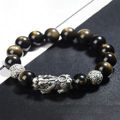 Gold Sheen Obsidian PiXiu Bracelet – Angled view of gold sheen obsidian beads with PiXiu on black surface