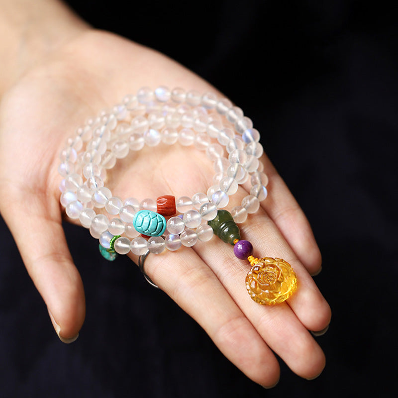 Moonstone Amber Turquoise Lotus Mala - Multi-strand bracelet on palm with carved amber rose, artisan jewelry