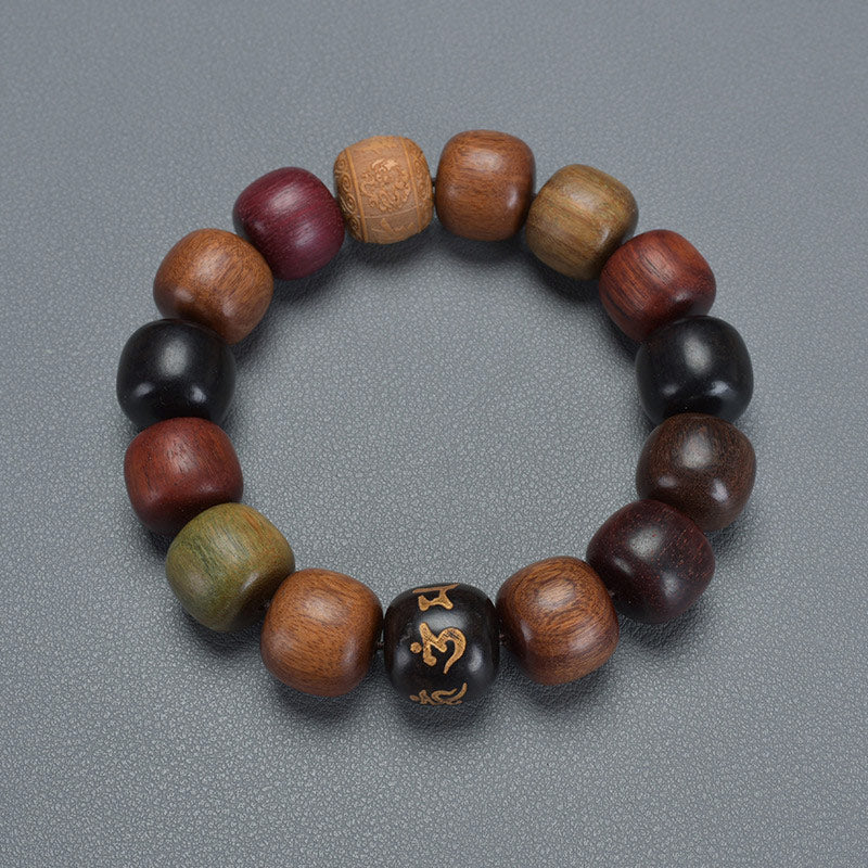 Various Wood Bracelet – overhead view of multi-wood bead loop with gold focal bead on gray, wood jewelry