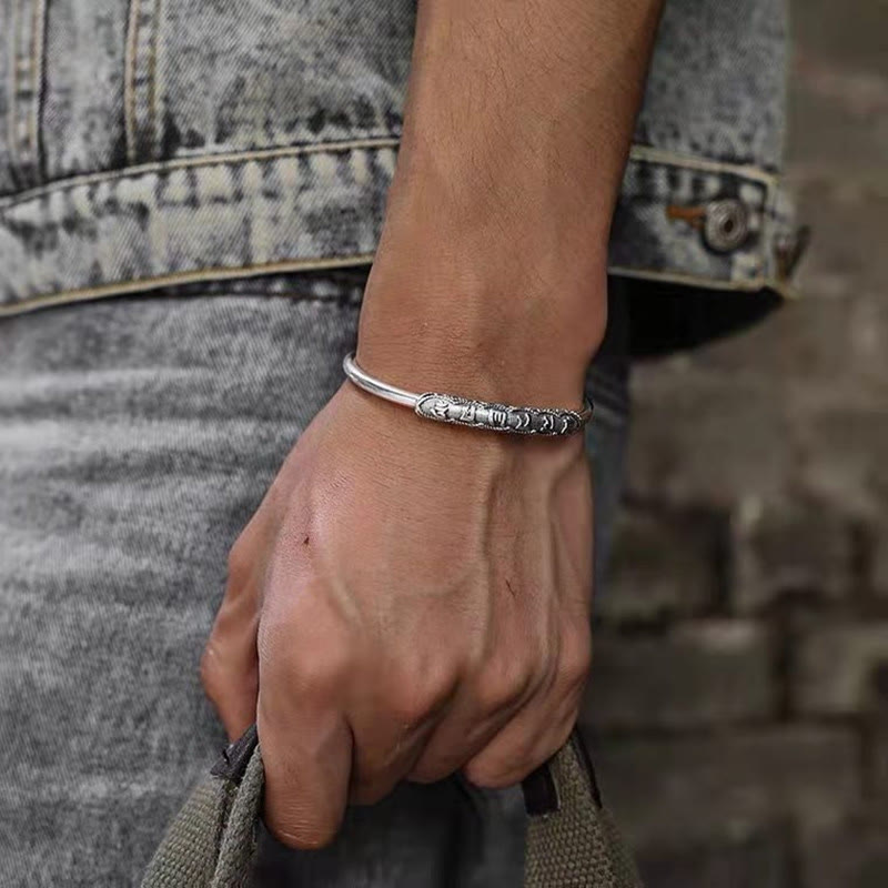 Om Mani Padme Hum Cuff Bracelet – Silver mantra cuff worn on wrist with denim jacket, men's style