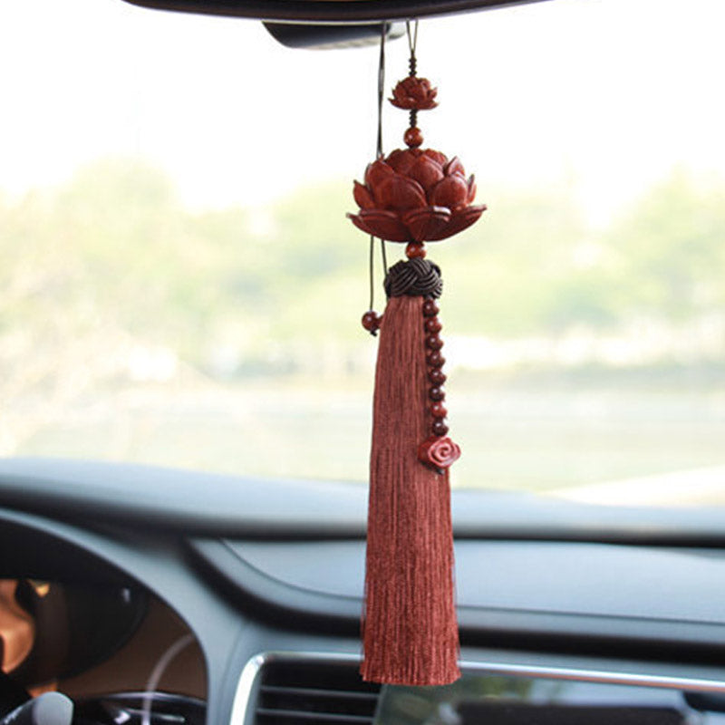 Red Sandalwood Lotus Tassel - lotus ornament hanging in car with greenery bokeh, serene