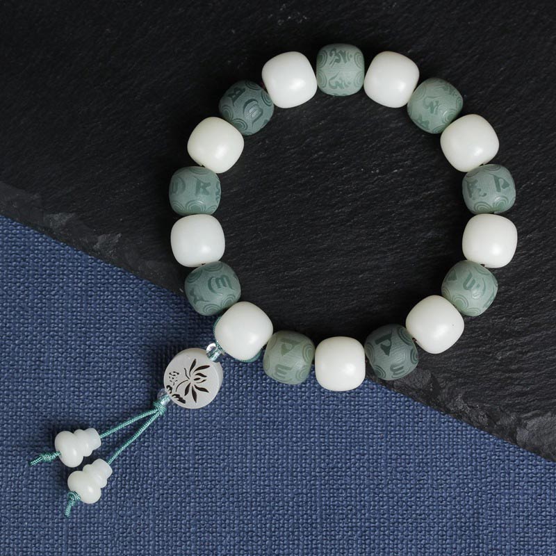 White Bodhi Seed Om Mani Padme Hum Bracelet – Flat lay on slate and linen, carved bodhi seed beads