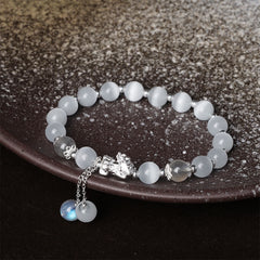 Cat's Eye PiXiu Bracelet – Bracelet on dark ceramic plate with silver PiXiu and dangling charms