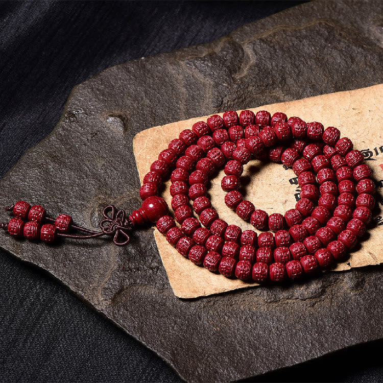 108 Mala Beads Cinnabar Bracelet – Atmospheric shot on stone, carved cinnabar mala