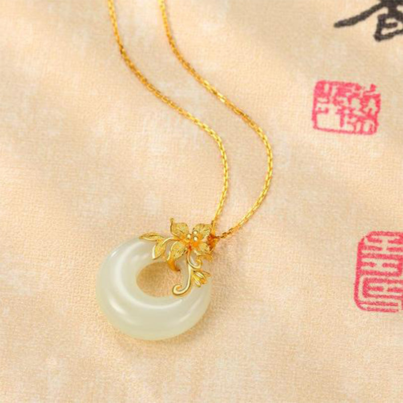 Tibetan White Jade Calm Necklace - macro on calligraphy backdrop with gold flower, jade necklace