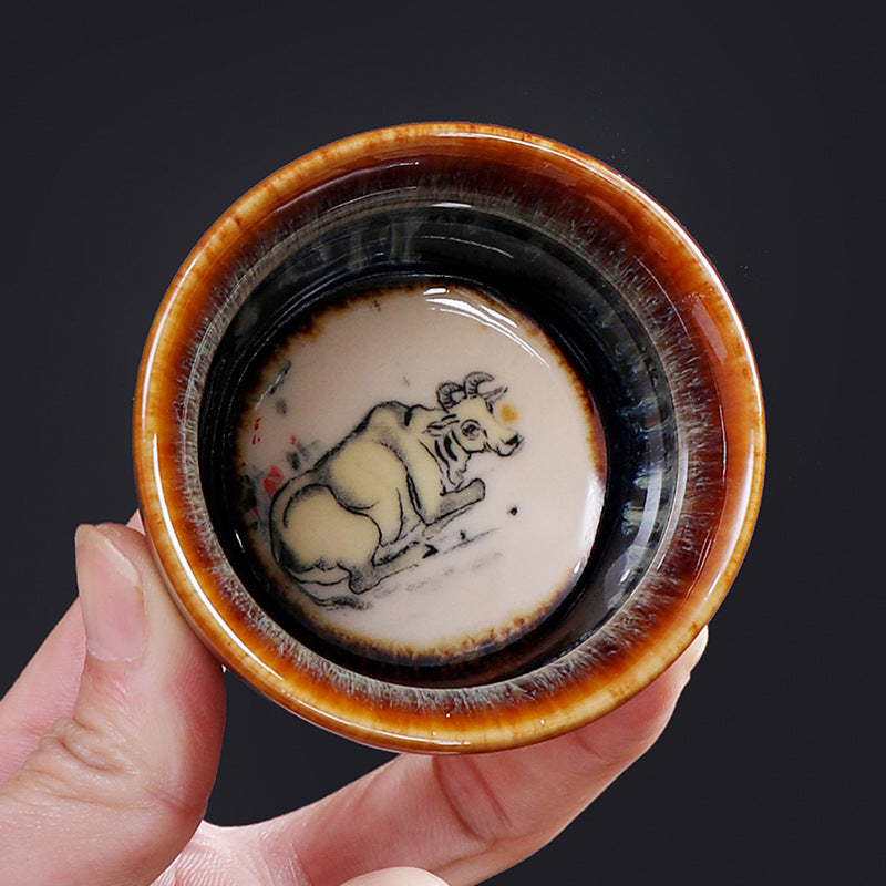 12 Zodiac Jian Zhan Teacup - Tiger zodiac dual view with ink-wash tiger medallion and iridescent amber-blue hare fur glaze