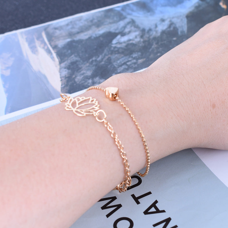 Lotus Heart Enlightenment Bracelet - Rose gold double bracelet on wrist with magazine background, enlightenment jewelry