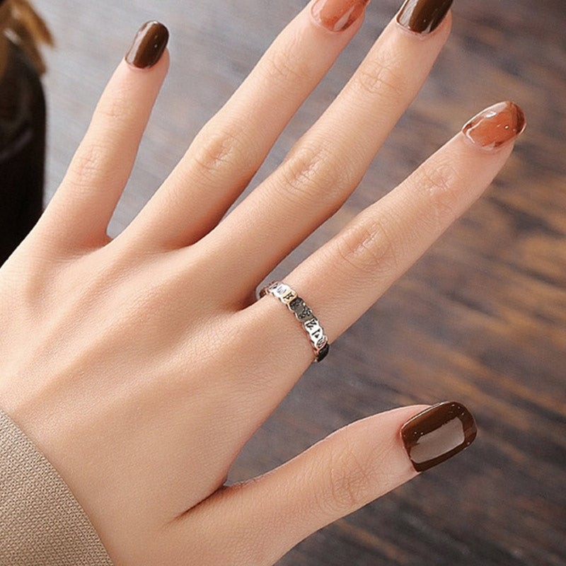 925 Sterling Silver Om Mani Padme Hum Ring – oxidized silver mantra band worn on hand against wood background, zen ring