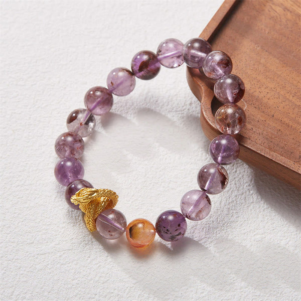 Purple Phantom Quartz Dragon Bracelet – 45-degree angle on wood tray highlighting amethyst inclusions and dragon, intuitive