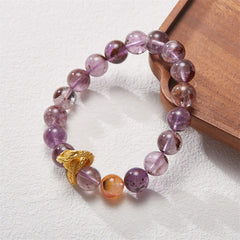 Purple Phantom Quartz Dragon Bracelet – 45-degree angle on wood tray highlighting amethyst inclusions and dragon, intuitive