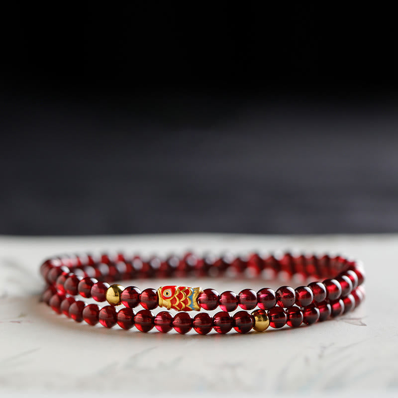 999 Gold Koi Fish Bracelet – side profile of koi charm, natural garnet stones, gold koi protection jewelry