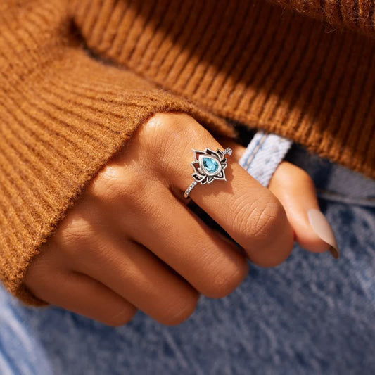 Sterling Silver Lotus Ring – Blue zircon lotus ring worn on hand with knit sweater, blessing jewelry