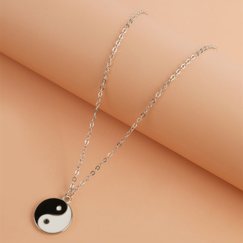 Yin Yang Pendant Necklace - Flat lay on warm peach background, alloy yin yang charm