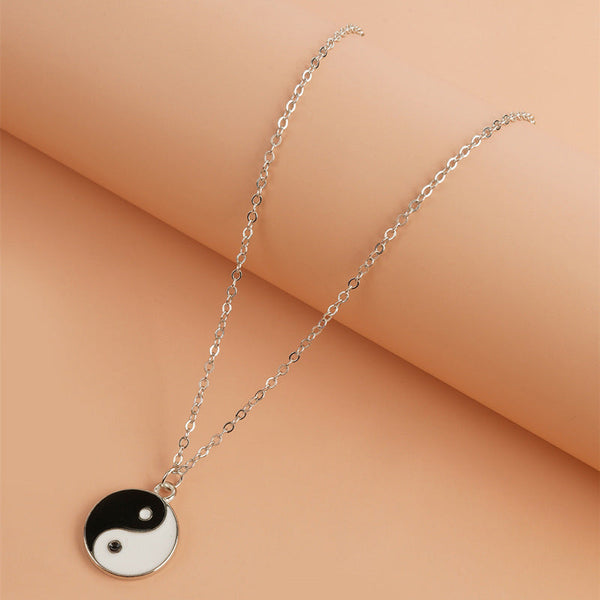 Yin Yang Pendant Necklace - Flat lay on warm peach background, alloy yin yang charm