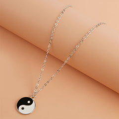 Yin Yang Pendant Necklace - Flat lay on warm peach background, alloy yin yang charm