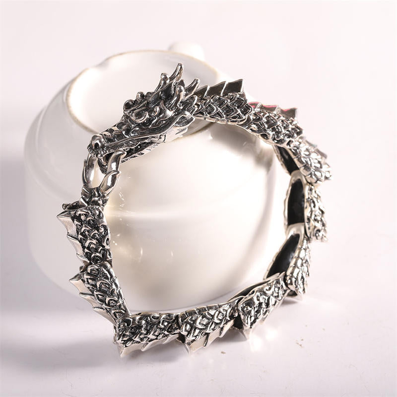 Sterling Silver Dragon Bangle - Coiled dragon bracelet on white ceramic vessel, premium elegance