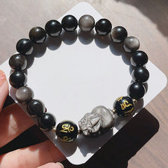 Silver Sheen & Black Obsidian PiXiu Bracelet – overhead flat lay on white card, carved mythical beast with inscribed mantr...