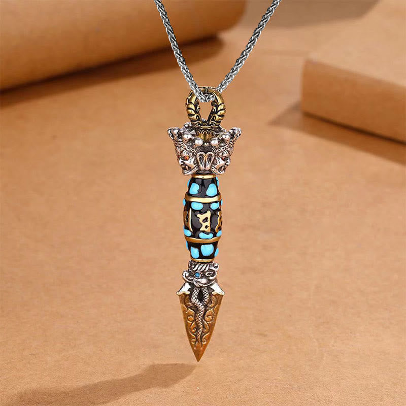 Tibetan Dzi Bead Dorje Pendant - Straight-on view on warm paper with turquoise barrel and serpent blade, spiritual jewelry