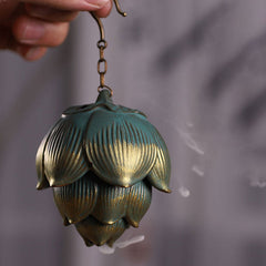 Lotus Hanging Incense Burner - Handheld verdigris lotus bud on chain, smoke wisps visible, meditation decor
