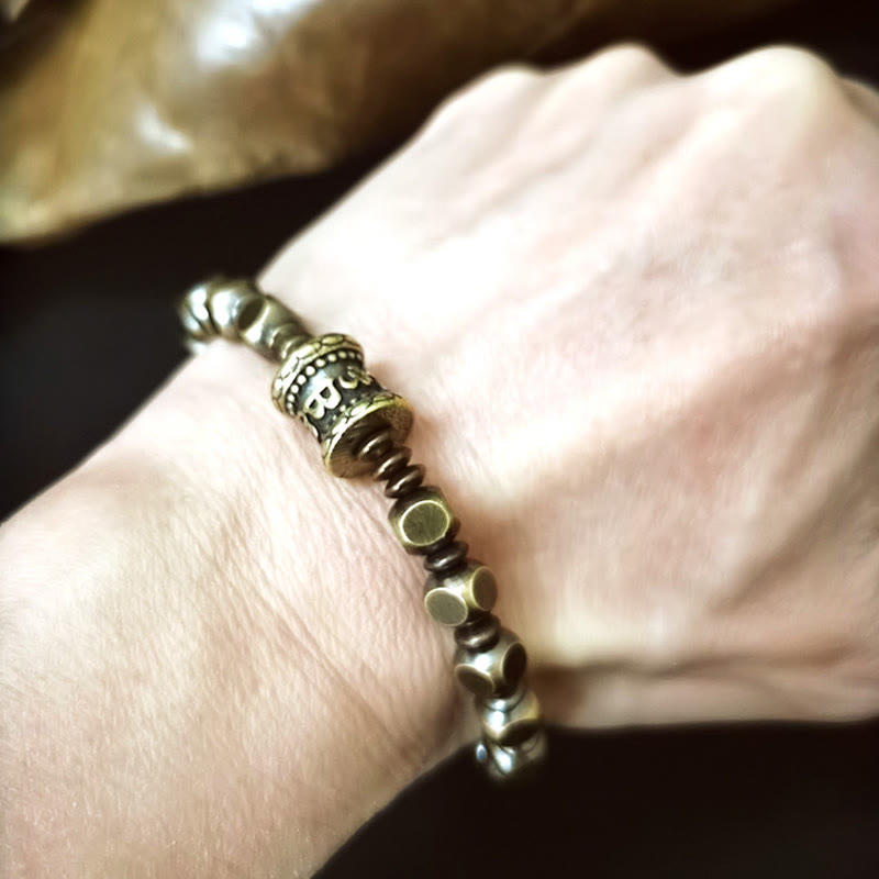 Brass Om Mani Padme Hum Bracelet – clean wrist shot on light background showing patina beads and carved focal piece, mindfulness jewelry