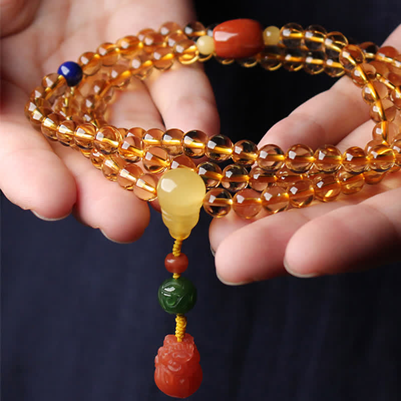 Citrine Mala Bracelet – Hands presenting citrine mala with carved red agate PiXiu guru bead