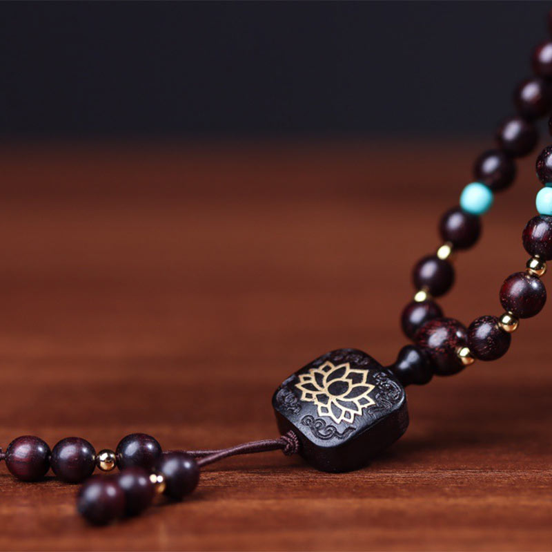 108 bead red sandalwood mala bracelet draped over Yixing clay teapot with Heart Sutra inscription, turquoise accents and gold lotus guru bead on dark wood surface