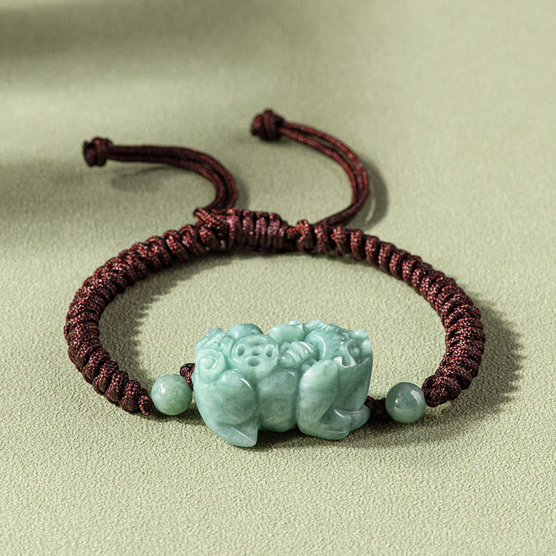 Jade PiXiu Knot Bracelet – Dark red braided cord bracelet with light green jade PiXiu on beige surface