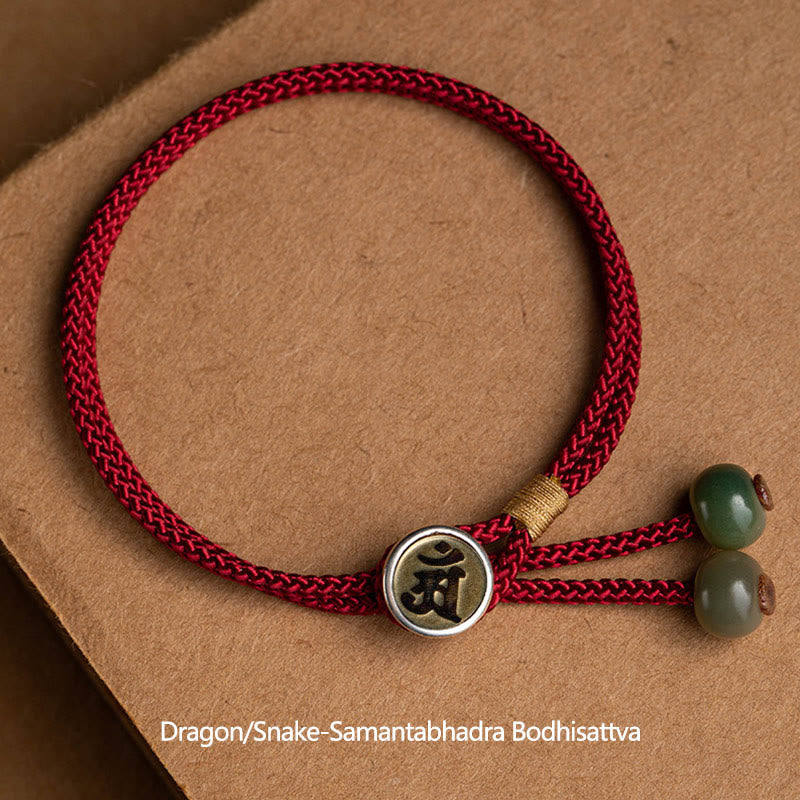 925 Silver Zodiac Natal Buddha Red String Bracelet flat lay, Dragon and Snake Samantabhadra Bodhisattva Sanskrit seed syllable charm, antique gold medallion with silver bezel, green stone terminal beads, burgundy cord Main image
