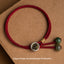 925 Silver Zodiac Natal Buddha Red String Bracelet flat lay, Dragon and Snake Samantabhadra Bodhisattva Sanskrit seed syllable charm, antique gold medallion with silver bezel, green stone terminal beads, burgundy cord