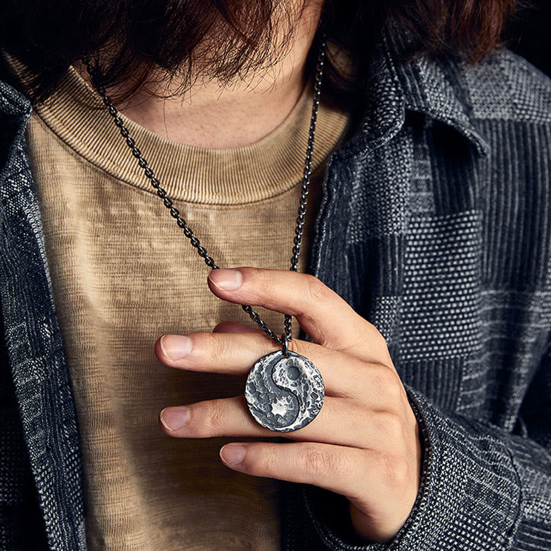 Sterling Silver Yin Yang Necklace – Lifestyle shot, model holding hammered yin-yang pendant on blackened chain