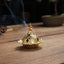 Mini Alloy Incense Burner – gold pierced dome censer with tiered spire finial, white smoke on wood