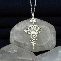 Lotus Luck Wealth Titanium Necklace – silver lotus unalome pendant on cable chain over gray stone, spiritual
