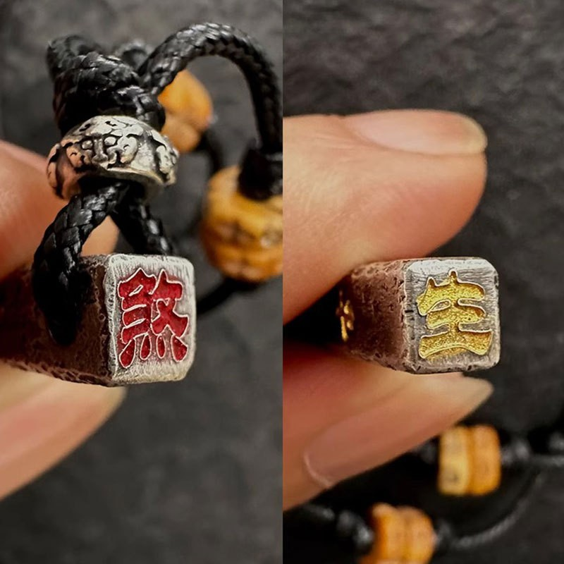 Tian Peng Chi Pendant – close-up of pendant ends showing red Sha and gold Bao characters, black braided cord and bead details, talisman