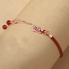 Shang An Koi Anklet – wrist close-up showing red koi charm with crystals and red bead tassels on rose gold chain, luxury